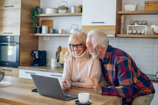 istock Senior couple having a video call while drinking coffee in the kitchen 2200785579