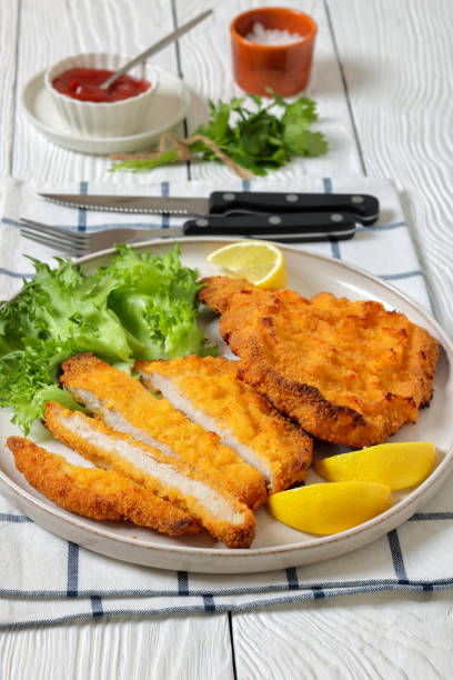 istock Pork Milanese with lettuce and lemon on a plate 2200786077