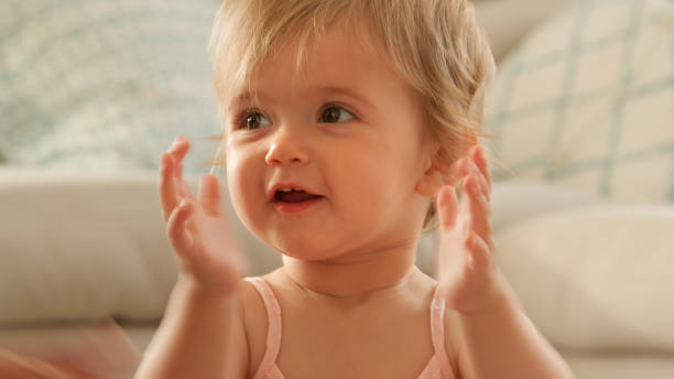 istock Young Girl Sitting On Floor At Home Clapping Hands Together 2200793514