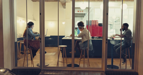 istock People, relax and tech in coffee shop for remote work, connectivity and networking at night. Store front, window and customers in cafe for small business support, deadlines and freelance opportunity 2200794033