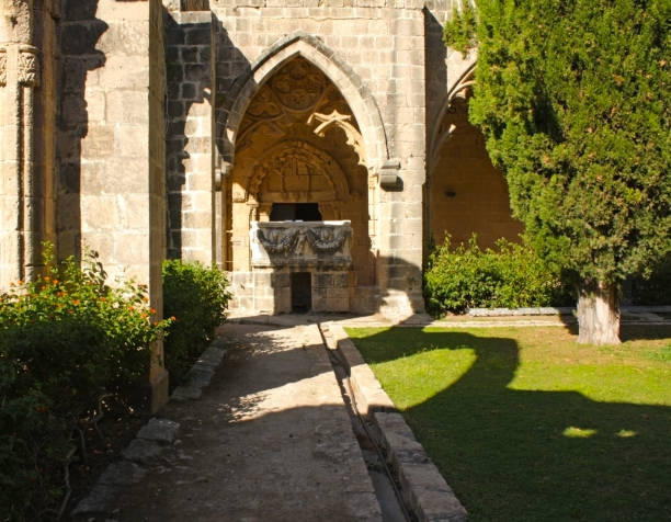 istock Sunlit gothic stone pathway and arched entrance with detailed carvings 2200794661