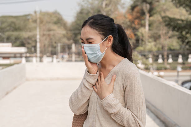 istock Diverse woman wearing a mask, expressing emotions outdoors in a city setting. 2200794742
