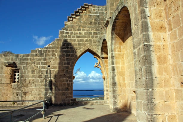 Stone archway with blue sky and sea in background, medieval ruins