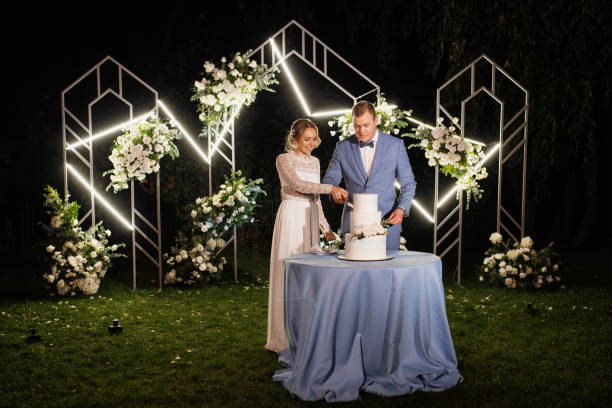 istock newlyweds happily cut and taste the wedding cake 2200796763