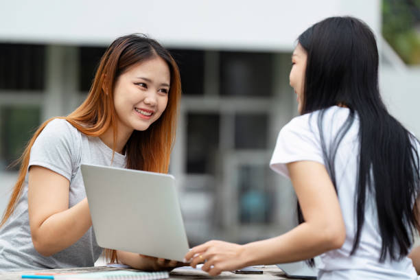 istock Diverse university students smiling and collaborating with a laptop. 2200798690
