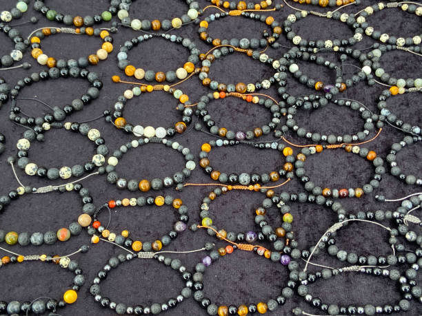 istock Handmade fashionable bracelets with lava stones on a black stone background.Top view. 2200802450