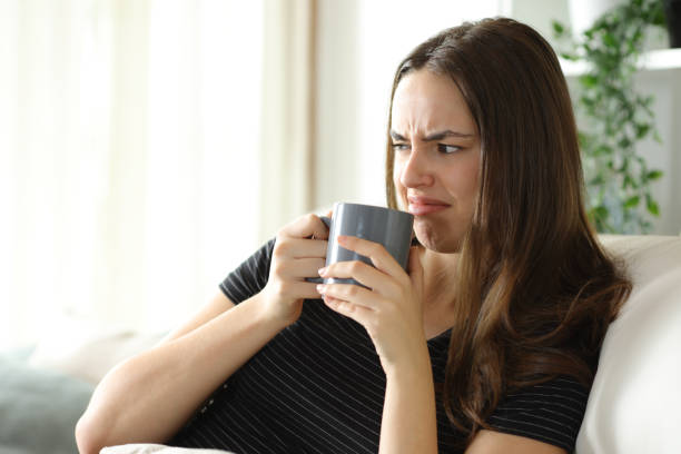 istock Disgusted woman smelling coffee at home 2200802769