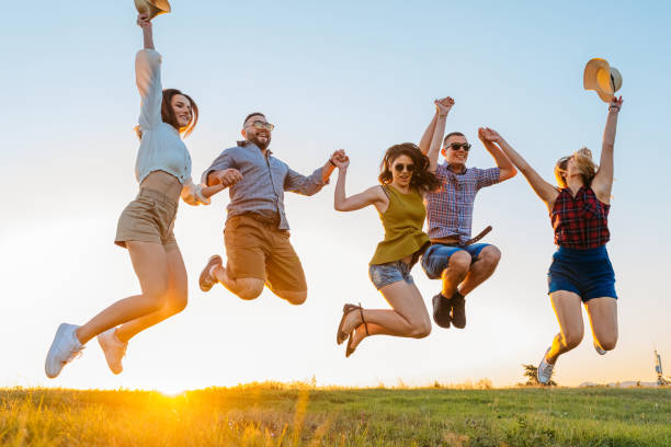 istock Group Of Friends Jumping In The Field At Sunset 2200806322