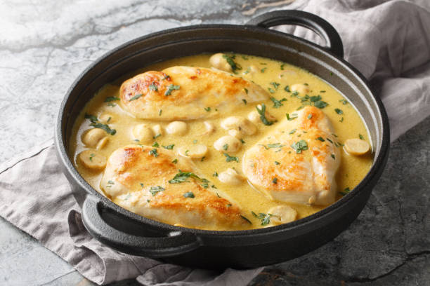 Chicken and mushrooms in a creamy lemon dijon sauce closeup in the skillet. Horizontal stock photo