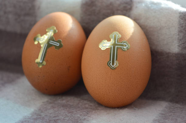 three brown Easter eggs decorated with golden Christian themed stickers crosses dove stars festive religious symbolism Easter celebrations traditions church events decorating food culture customs