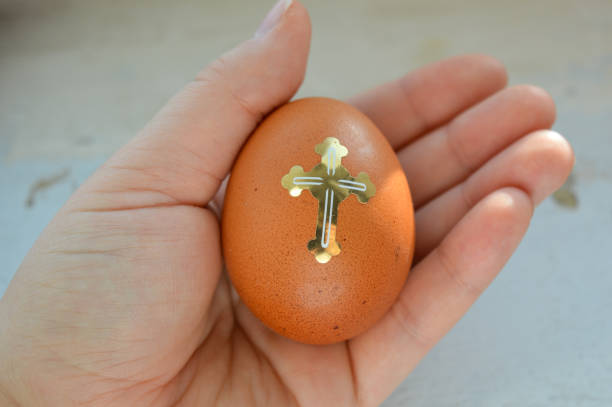three brown Easter eggs decorated with golden Christian themed stickers crosses dove stars festive religious symbolism Easter celebrations traditions church events decorating food culture customs