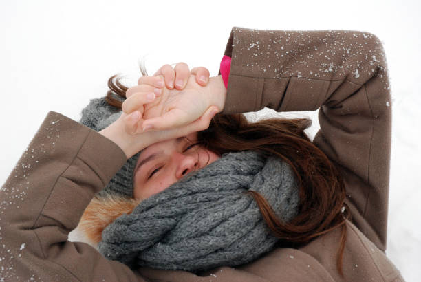 Cozy winter joy, smiling woman in warm clothes lying on snow.