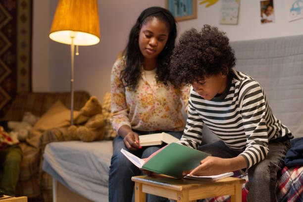 Mother and little son reading book together at home
