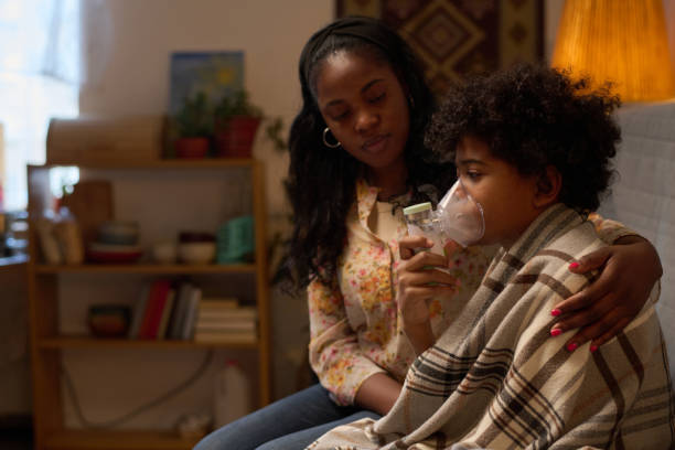 istock Mother Assisting Sick Child Sitting on Couch 2200812351