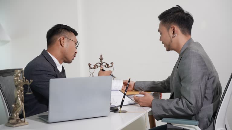 Businessman and lawyer talking and making a contract together Signing a legal document contract, hammer on the table. Legal concept. Transaction. Work environment.