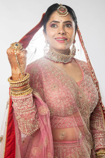 istock Beautiful bride in traditional attire posing over white background 2200815224