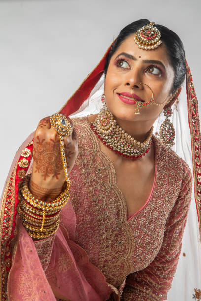 istock Smiling bride in pink wedding dress standing on white background 2200815523