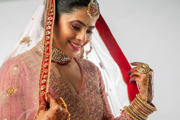 istock Smiling bride in pink wedding dress standing on white background 2200815646