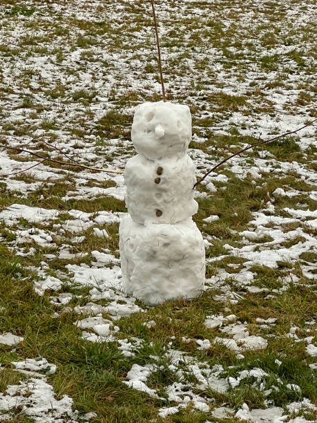 istock A small, modest snowman placed in a meadow made of leftover snow 2200818544