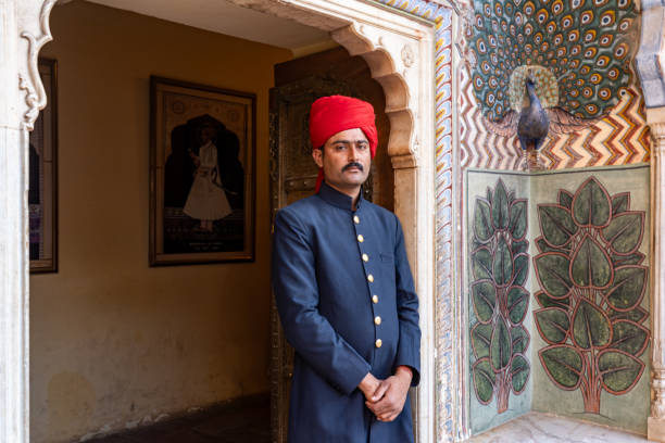 India. Rajasthan. Jaipur. City Palace. A guard stand front of the Peacock Gate decorated with peacock motifs, it symbolizes autumn and is dedicated to the god Vishnu. One of the four gates known as Ridhi Sidhi Pol in the inner courtyard of the Chandra Mahal