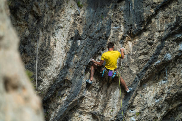 Conquering the heights: man rock climbing with determination.