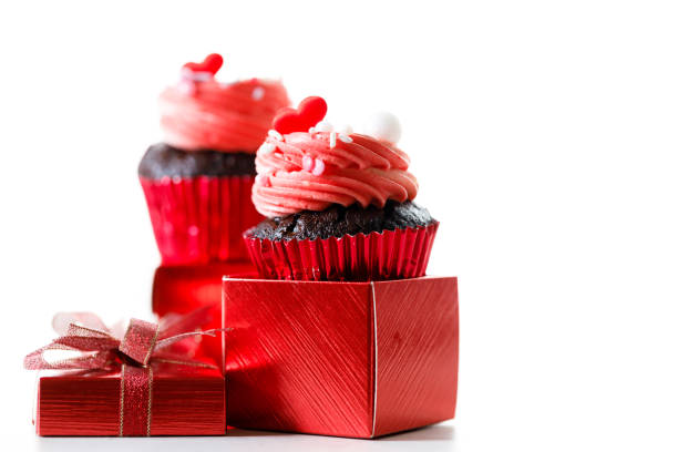istock Chocolate cupcakes with pink cream and heart shaped sprinkles. 2200828178