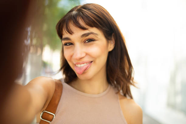 istock Cute young woman taking selfie outside 2200828275
