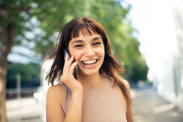 istock Cheerful young woman using cellphone outside in city 2200828338