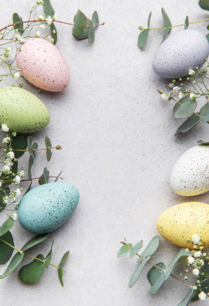 istock Easter eggs and eucalyptus leaves forming a frame on gray background 2200831530