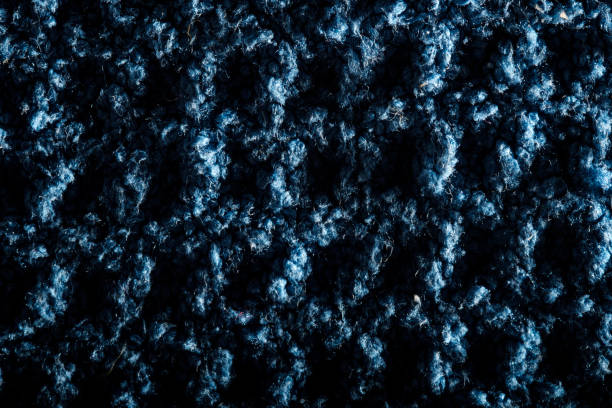 Macro photography captures the intricate texture of blue wool fabric, highlighting individual fibers and creating a visually rich tapestry of depth and detail