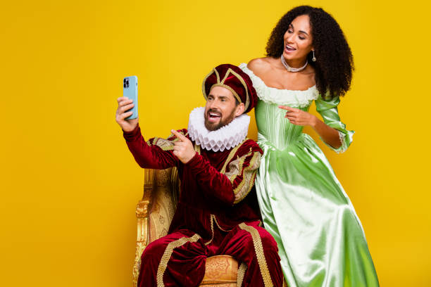 istock Man and woman in historical costumes expressing joy while using a smartphone in a vibrant setting 2200837764
