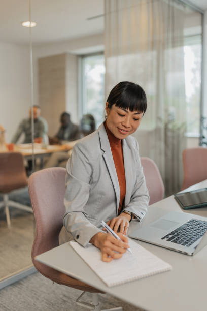 istock Focused businesswoman making notes in a meeting 2200838555