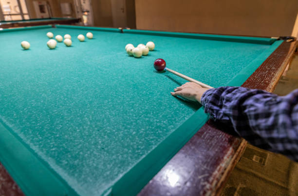 istock Hand with cue aiming on billiard ball at table 2200838884