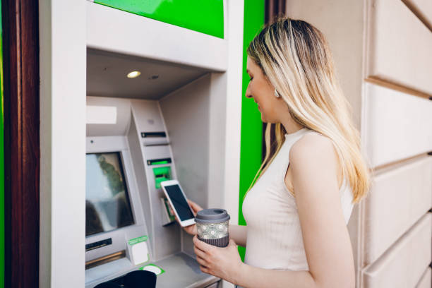 istock Young woman using the ATM 2200839854