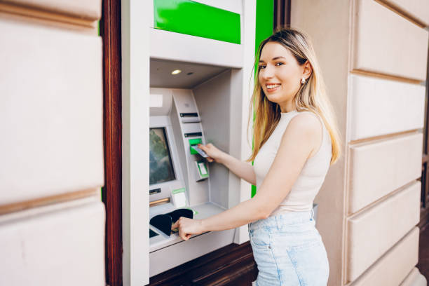 istock Young woman using the ATM 2200840688