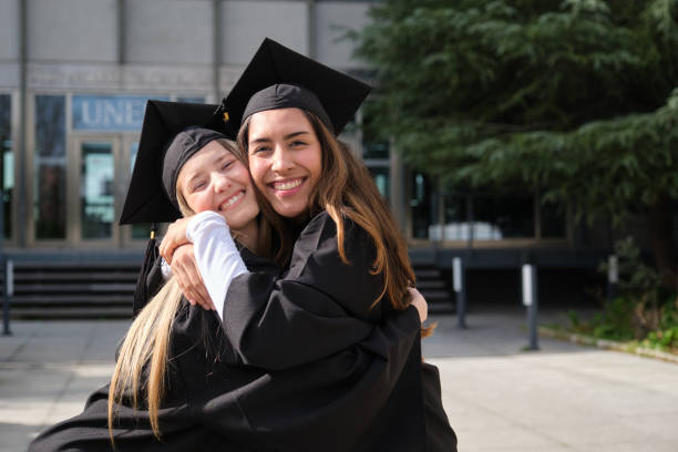 istock Two happy students hugging each other on graduation day 2200843750