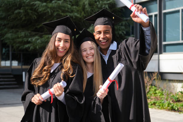 istock Happy graduated students smiling and holding their diplomas 2200845237