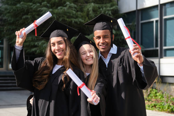 istock Happy graduating students holding diplomas and smiling at camera 2200845444