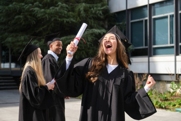 istock Excited graduating student holding diploma celebrating with colleagues 2200846739