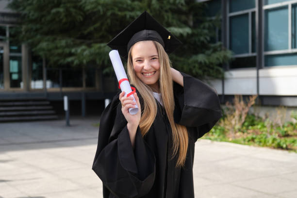 istock Young graduate student smiling and holding her diploma 2200847517