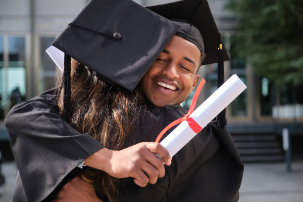 istock Two happy students hugging each other after graduation ceremony 2200847739
