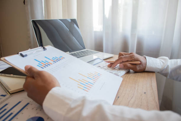 istock A man's hands are typing on a laptop and mobile phone while reviewing investment documents and using a calculator and computer to analyze to reduce risk.w 2200847921