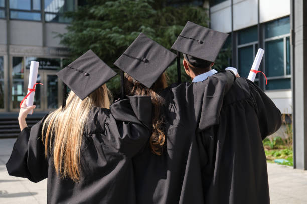 istock Graduates celebrating graduation day holding diplomas 2200847949