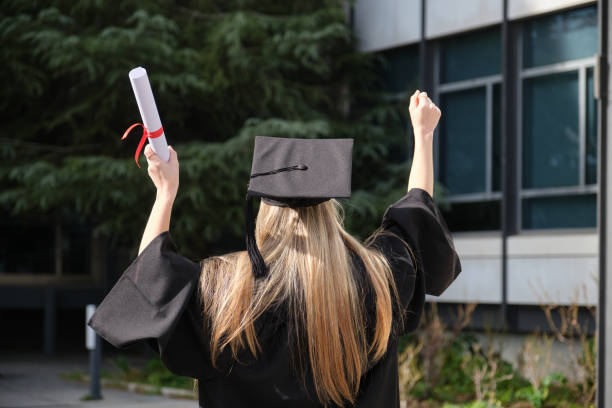istock Excited graduating student raising diploma and celebrating with arms up 2200848248