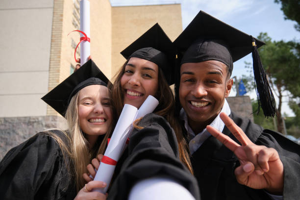 istock Happy multi-ethnic graduates taking a selfie holding their diplomas and smiling at camera 2200850074