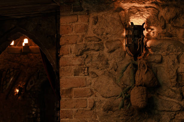 A historic street lamp, glowing orange, hangs in a white stone passageway. A dark arch runs through the picture.