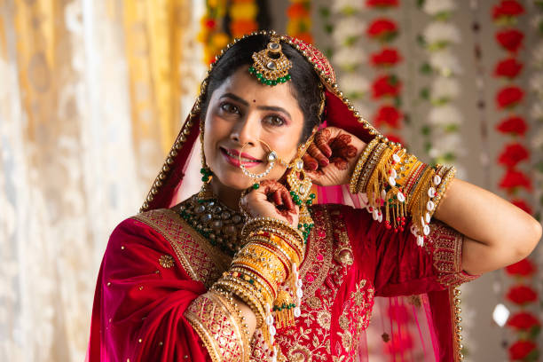 istock Beautiful smiling bride dressed in traditional clothing adjusting her earring 2200850482