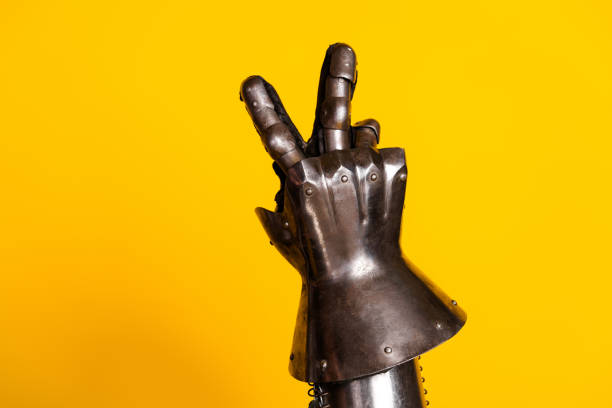 istock Medieval armored hand showing peace gesture against vibrant yellow background 2200851023