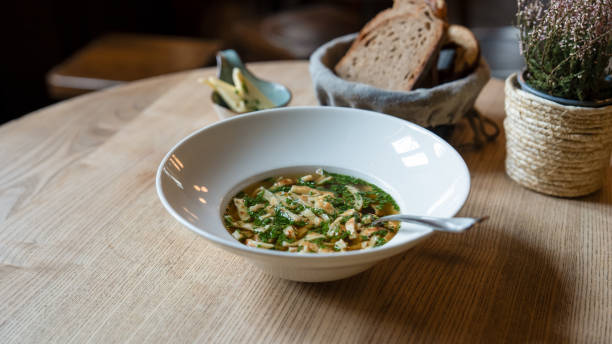 istock Traditional Pancake Soup with Beef Broth, Pancake Strips, and Fresh Herbs, Served with Bread and Butter in a Cozy Bavarian Tavern 2200852804
