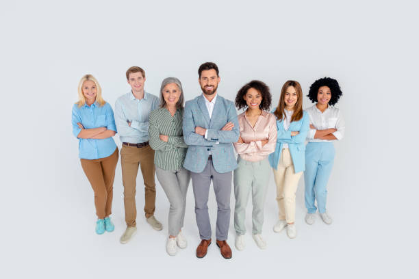 istock Group of diverse professionals standing together confidently against a grey background, showcasing teamwork, partnership, and leadership 2200853225